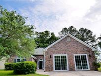 Charming brick home featuring a well-manicured lawn and a welcoming entrance with detailed trim work at 104 Jessica Lakes Dr., Conway, SC 29526