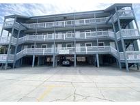 Attractive three story building with ample covered parking and stairs leading up to covered walkways in front of each unit at 116 S Waccamaw Dr. # 205, Murrells Inlet, SC 29576