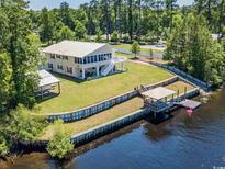 Beautiful waterfront home with a dock, gazebo, lush lawn, and mature trees at 134 Mohican Dr., Georgetown, SC 29440