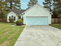 Charming single-story home with a two-car garage, well-kept lawn, and mature trees at 185 Lander Dr., Conway, SC 29526