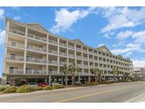 Spacious condo complex featuring multiple stories and balconies with parking underneath near landscaped green space at 200 53Rd Ave. N # 511, North Myrtle Beach, SC 29582