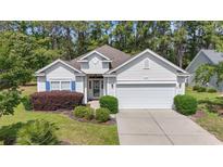 Charming one-story home with manicured lawn, two-car garage, and beautiful landscaping at 205 Carriage Lake Dr., Little River, SC 29566