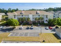 Two-story condo with balconies, palm trees, and a large parking area at 334 Kiskadee Loop # 18-L, Conway, SC 29526