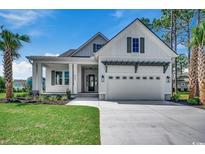 Inviting two-story home featuring a covered front porch, attached two-car garage, and well-manicured lawn at 404 Plantation Oaks Dr., Myrtle Beach, SC 29579