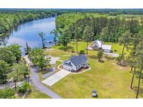 Stunning waterfront home with large lawn, mature trees, and private dock on the river at 4074 Center Rd., Georgetown, SC 29440