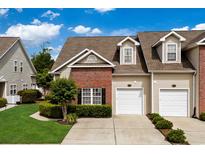 Charming townhome featuring brick accents, manicured landscaping, and two-car garages at 4355 Willoughby Ln. # 401, Myrtle Beach, SC 29577
