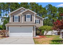 Charming two-story home featuring a two-car garage, manicured lawn, and classic curb appeal with black shutters at 480 Dandelion Ln., Myrtle Beach, SC 29579