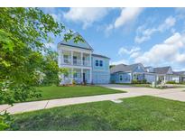 Charming two-story home with a manicured lawn and a welcoming double porch at 5545 Whitebark Dr., Myrtle Beach, SC 29577