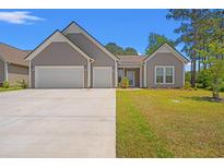 Charming single-story home featuring a two-car garage, well-manicured lawn, and lovely front porch at 57 Eagle Claw Dr., Carolina Shores, NC 28467