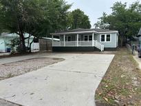 Charming single-story home with a spacious driveway and inviting front porch, perfect for relaxation at 803 34Th Ave. S, North Myrtle Beach, SC 29582