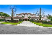 Stunning multi-story home with manicured landscaping, a private driveway, and multiple car garages on a sunny day at 8546 San Marcello Dr. # 1-102, Myrtle Beach, SC 29579