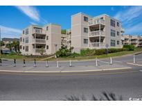 Exterior view of condominiums with balconies and tropical landscaping on a sunny day with a beautiful blue sky at 9661 Shore Dr. # B-3, Myrtle Beach, SC 29572