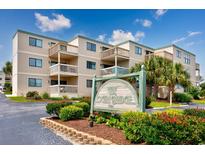 Beautiful condo building with lush landscaping and a charming sign, offering a serene and inviting atmosphere at 9661 Shore Dr. # B-3, Myrtle Beach, SC 29572