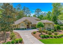 Inviting single-story home boasts lush landscaping, mature trees, and a welcoming front porch at 1206 Spinnaker Dr., North Myrtle Beach, SC 29582