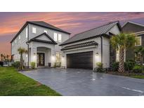 Stunning two-story home featuring a modern design, a two-car garage, and lush landscaping at 1279 Fiddlehead Way, Myrtle Beach, SC 29579