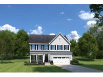 Charming two-story home featuring classic architectural design, a landscaped yard, and an attached two-car garage at 1312 Piper Glen Dr, Sunset Beach, NC 28468
