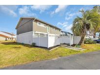 Charming exterior showcasing a well-maintained home with a white fence and lovely palm tree at 1360 Turkey Ridge Rd. # A, Surfside Beach, SC 29575
