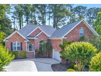 Charming brick home with mature landscaping, a well-manicured lawn, and an attached two car garage at 154 Windsor Circle Sw, Ocean Isle Beach, NC 28469