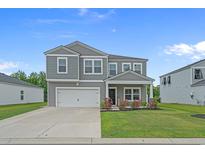 Charming two-story home with a well-manicured lawn and attached two-car garage at 155 S Reindeer Rd., Surfside Beach, SC 29575