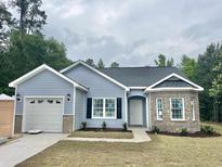 Charming single-story home featuring a brick and vinyl exterior, attached garage and a well manicured front yard at 2593 Main St., Loris, SC 29569