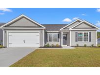 Charming single-story home featuring a two-car garage, and manicured lawn with inviting curb appeal at 271 Stillbrook Dr., Longs, SC 29568