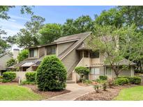Two-story condo features beautiful landscaping, stairs to the front door, and neutral toned siding at 400 Melrose Pl. # 14E, Myrtle Beach, SC 29572