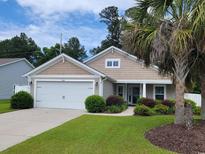 Charming single-Gathering home with a well-manicured lawn, landscaped shrubbery and a two car garage at 424 Enderby Way, Little River, SC 29566