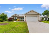 Charming single-story home features a 2-car garage, well-manicured lawn, and colorful landscaping at 4419 Kinlaw St., Little River, SC 29566