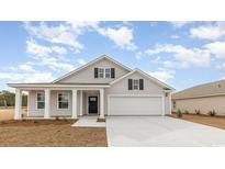 Charming single-Gathering home with a gray shingle exterior, black shutters, and a two-car garage at 4465 East Coast Ln., Shallotte, NC 28470