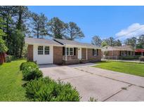 Charming brick home with a well-manicured front yard and a concrete driveway at 450 Player St., Georgetown, SC 29440