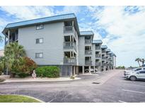 Coastal condo building featuring multiple floors with private balconies and ample parking space at 6000 N Ocean Blvd. # 133, North Myrtle Beach, SC 29582