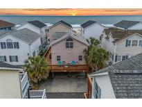 Charming coastal home with a large deck and palm trees, situated near a beautiful beach at sunset at 6001 - B7 S Kings Hwy., Myrtle Beach, SC 29575