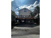 Charming raised beach house with covered parking, deck, and coastal vibes and palm trees at 6001 - B7 S Kings Hwy., Myrtle Beach, SC 29575