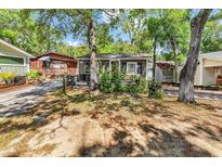 Charming cottage exterior with mature trees, a red door, and dark shutters at 6001-N74 South Kings Hwy., Myrtle Beach, SC 29575