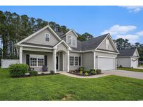 Charming home with a well-manicured lawn, lush landscaping, and a two-car garage at 630 Heartwood Dr., Conway, SC 29526