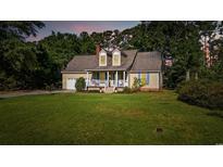 Charming single-Gathering home featuring a manicured lawn, attached garage, and inviting front porch at 645 Boundary Line Dr. Nw, Calabash, NC 28467