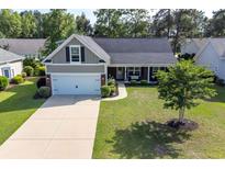 Charming single-Gathering home with a well-manicured lawn, attached garage, and inviting front porch at 672 Ashley Manor Dr., Longs, SC 29568
