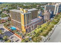 An aerial view of the condo with oceanfront views, pool, and lush landscaping at 6900 N Ocean Blvd. # 1437, Myrtle Beach, SC 29572