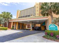 View of the building entrance with covered parking and well-maintained landscaping at 6900 N Ocean Blvd. # 710, Myrtle Beach, SC 29572