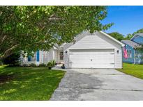 Charming home featuring an attached two-car garage, lush lawn, and mature tree at 9607 Kings Grant Dr., Murrells Inlet, SC 29576