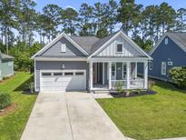 Charming single-story home featuring a welcoming front porch, attached garage, and a well-manicured lawn at 1007 Longwood Bluffs Circle, Murrells Inlet, SC 29576