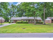 Charming single-story brick home featuring a well-manicured lawn and mature shade trees at 1108 Chicora Blvd., Conway, SC 29526