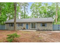 Charming single-story brick home with blue shutters and a well-maintained front yard surrounded by mature trees at 1111 King St., Myrtle Beach, SC 29577