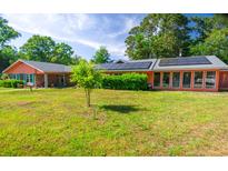 Single-story house with solar panels, a spacious lawn, and a brick exterior at 152 Gateway Dr., Little River, SC 29566