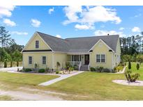 Charming single story home featuring a manicured lawn, beautiful landscaping, and a quaint front porch at 1763 Hemingway Rd., Loris, SC 29569