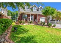 Charming brick home featuring a beautifully landscaped yard with a welcoming front porch at 2019 Ye Olde Kings Hwy., North Myrtle Beach, SC 29582