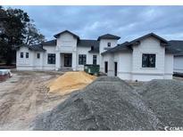 Striking two-story home with a modern design and a symmetrical facade under a cloudy sky at 4300 Gray Heron Dr., North Myrtle Beach, SC 29582
