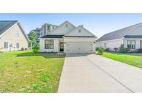 Charming single-Gathering home showcasing a well-manicured lawn and a convenient two-car garage at 4363 Bayshore Dr., Little River, SC 29566