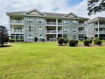 Well-maintained condo with multiple balconies, stone facade, manicured lawn, and professional landscaping at 4783 Wild Iris Dr. # 101, Myrtle Beach, SC 29577