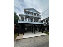 Coastal home featuring a blue exterior, multiple decks, and elevated construction for stunning views and convenient parking at 6001 - 1793 S Kings Hwy., Myrtle Beach, SC 29575